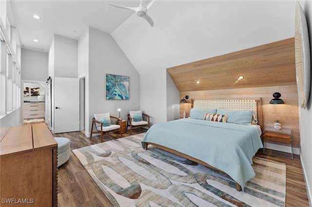 bedroom featuring wood walls, ceiling fan, dark hardwood / wood-style floors, and high vaulted ceiling