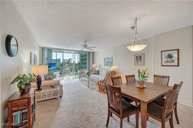 carpeted dining area featuring ceiling fan, expansive windows, and a textured ceiling