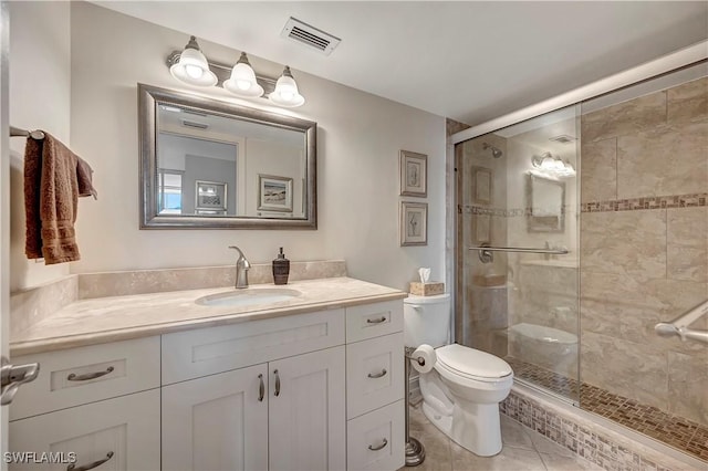 bathroom with vanity, tile patterned floors, a shower with door, and toilet