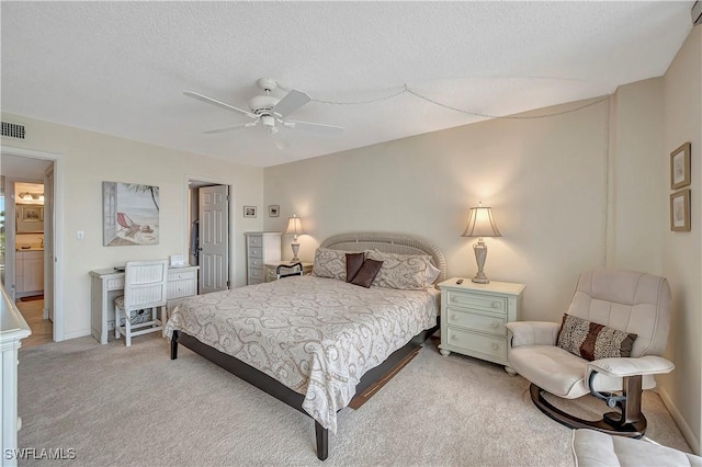 carpeted bedroom with ceiling fan and a textured ceiling