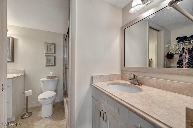 bathroom featuring an enclosed shower, vanity, tile patterned floors, and a textured ceiling