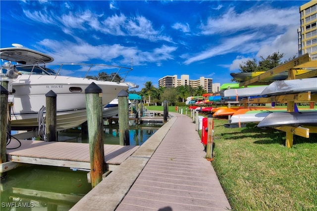 view of dock with a water view and a yard