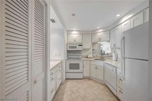 kitchen featuring white cabinetry, white appliances, sink, and light tile patterned floors