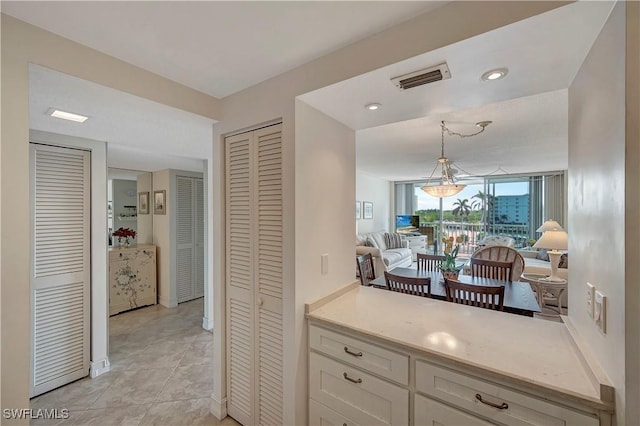 kitchen featuring white cabinetry, pendant lighting, and light tile patterned floors