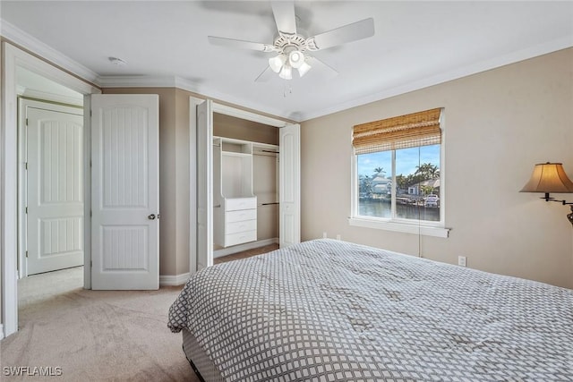 bedroom with light carpet, a water view, crown molding, ceiling fan, and a closet