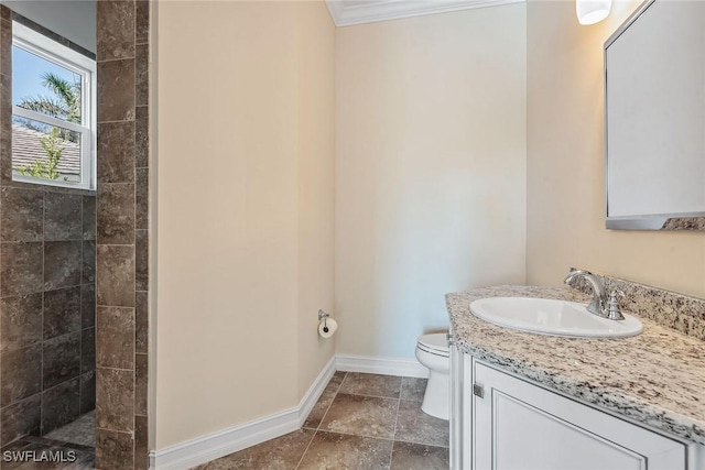 bathroom with vanity, toilet, a shower, and crown molding