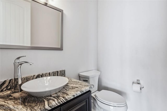 bathroom featuring vanity and toilet