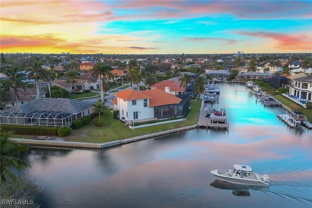 aerial view at dusk featuring a water view