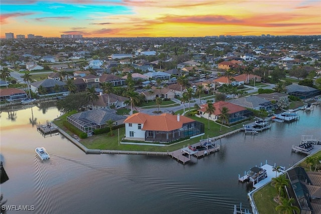 aerial view at dusk featuring a water view