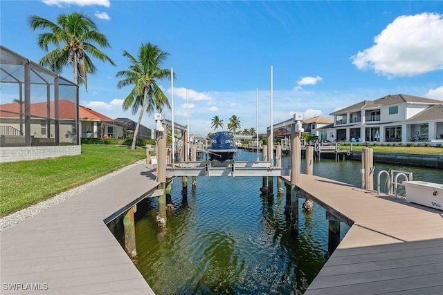 dock area with a lawn, glass enclosure, and a water view