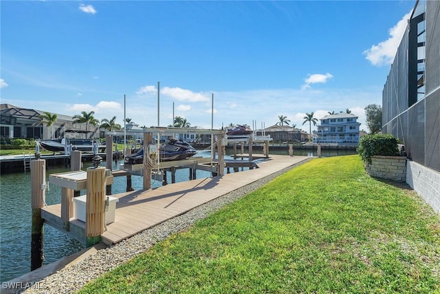 view of dock with a yard and a water view