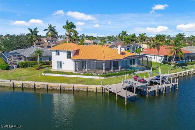 exterior space with glass enclosure, a water view, and a yard