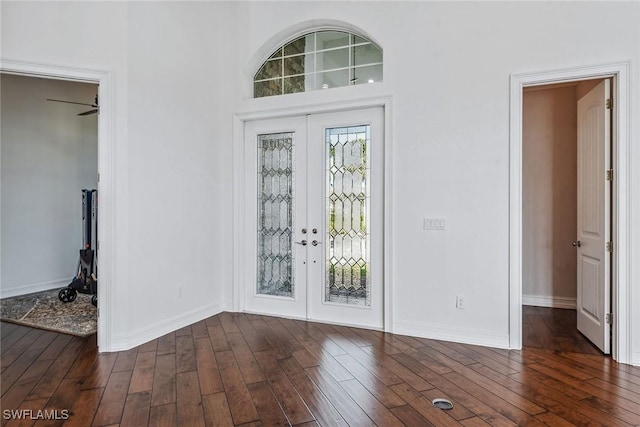 foyer with ceiling fan, a towering ceiling, dark wood-type flooring, and french doors