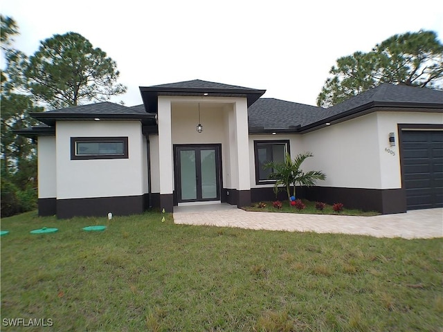 view of front facade with a front lawn, french doors, and a garage