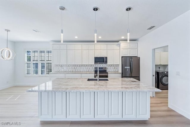 kitchen with decorative light fixtures, stainless steel appliances, a large island, and decorative backsplash