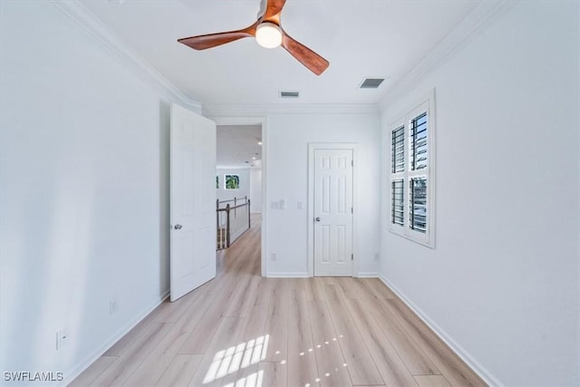 empty room with ceiling fan, ornamental molding, and light hardwood / wood-style flooring