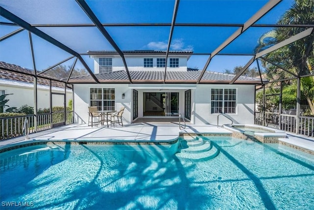 view of pool featuring a patio, glass enclosure, and an in ground hot tub