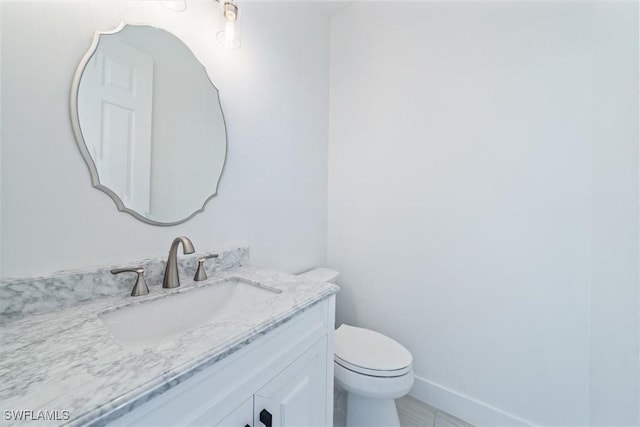 bathroom with toilet, tile patterned flooring, and vanity