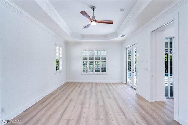 empty room featuring ceiling fan, french doors, crown molding, and a tray ceiling