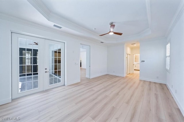 unfurnished room featuring a raised ceiling, ceiling fan, and french doors