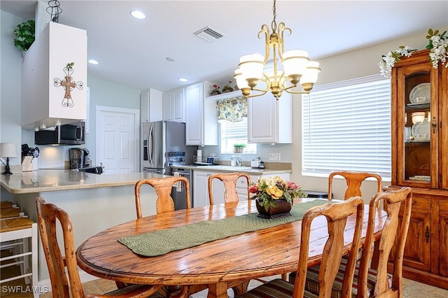 dining area with a chandelier and lofted ceiling