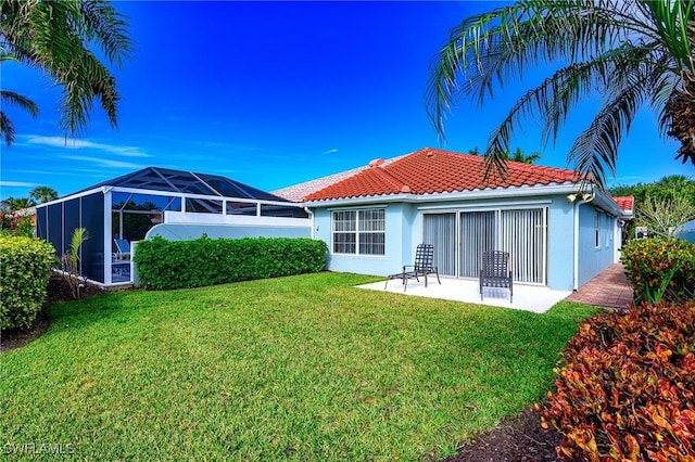 rear view of house with glass enclosure, a yard, and a patio