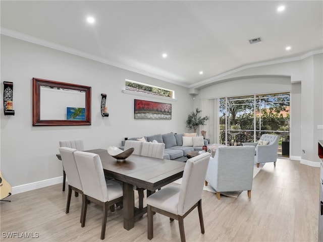 dining space with crown molding and light hardwood / wood-style floors