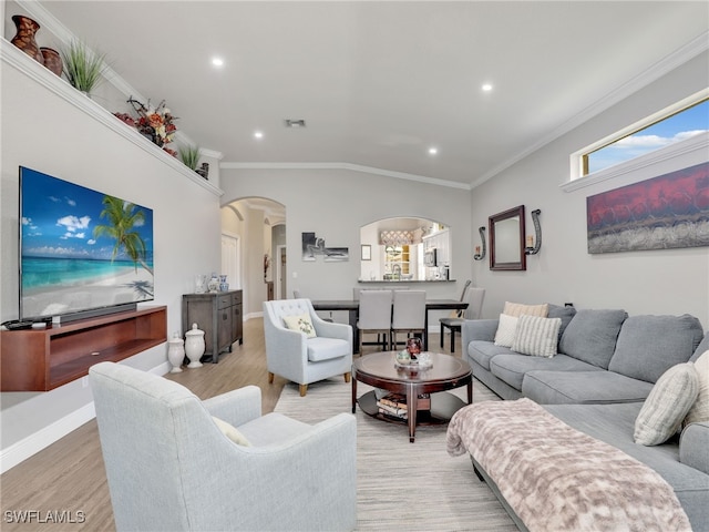 living room featuring crown molding, lofted ceiling, and light hardwood / wood-style flooring