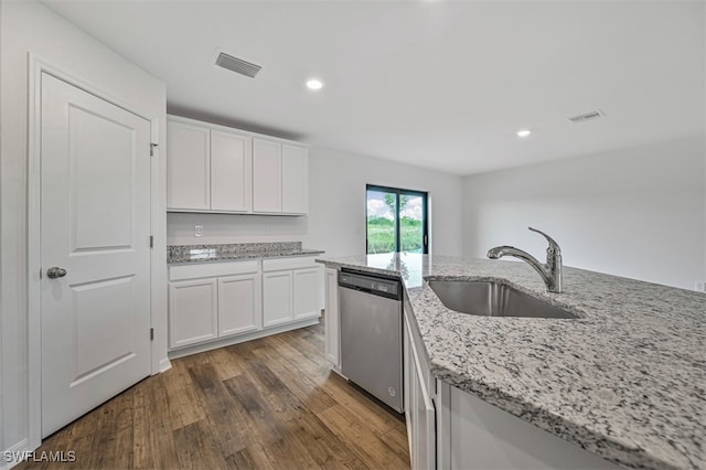 kitchen with dark hardwood / wood-style flooring, stainless steel dishwasher, light stone counters, sink, and white cabinets