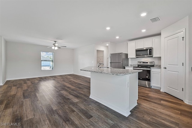 kitchen with white cabinetry, sink, stainless steel appliances, dark hardwood / wood-style floors, and an island with sink