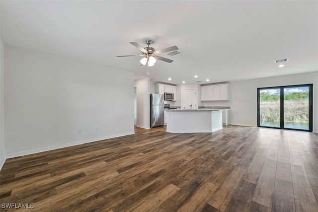 unfurnished living room featuring ceiling fan and dark hardwood / wood-style floors