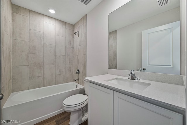 full bathroom with hardwood / wood-style floors, vanity, toilet, and tiled shower / bath