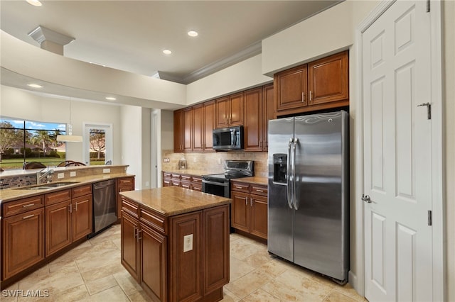 kitchen featuring backsplash, sink, light stone countertops, a kitchen island, and stainless steel appliances