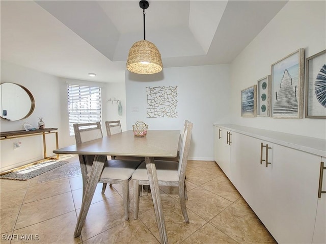 tiled dining room with a tray ceiling