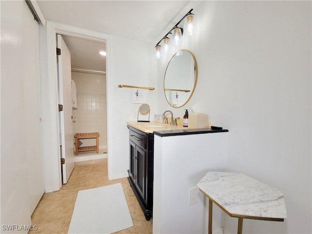 bathroom featuring a tile shower, tile patterned flooring, and vanity