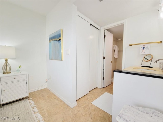 corridor featuring light tile patterned flooring and sink