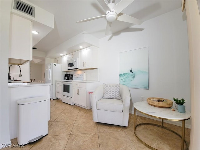 kitchen with ceiling fan, sink, light tile patterned flooring, white appliances, and white cabinets