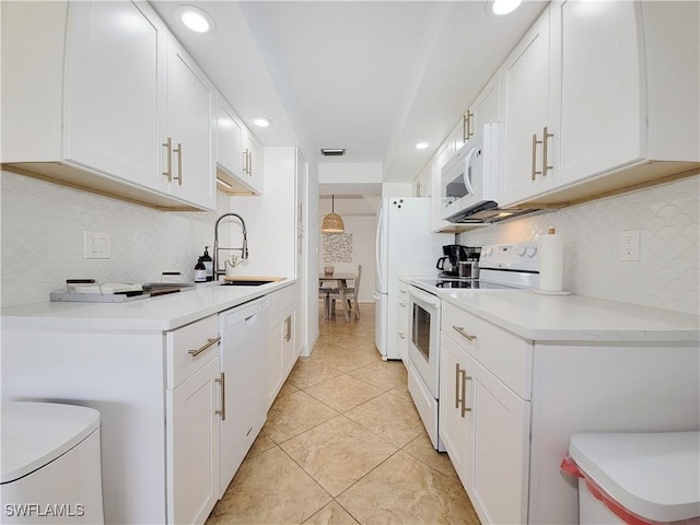 kitchen with decorative backsplash, white cabinetry, sink, and white appliances