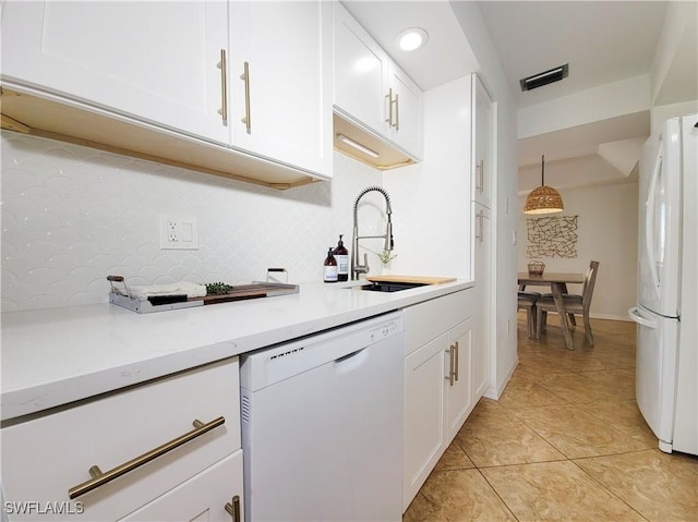 kitchen with white appliances, sink, light tile patterned floors, white cabinets, and hanging light fixtures