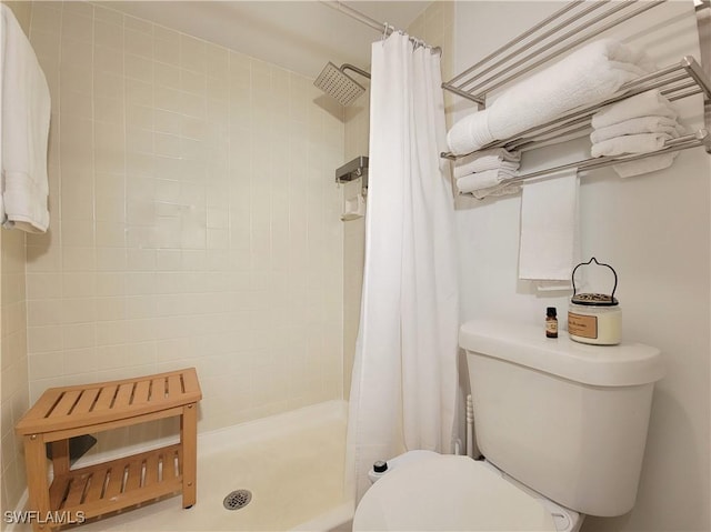 bathroom with curtained shower and toilet