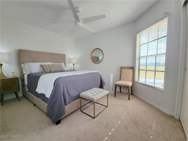 bedroom with ceiling fan, light carpet, and multiple windows