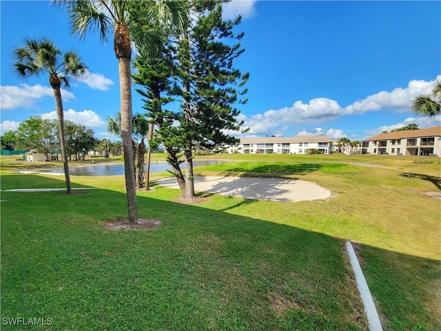 surrounding community featuring a lawn and a water view