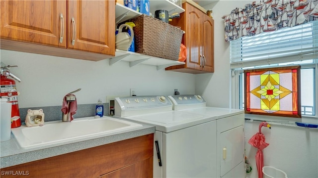 washroom featuring sink, separate washer and dryer, and cabinets