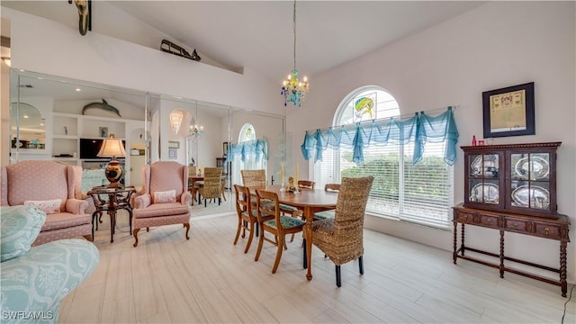 dining area featuring vaulted ceiling, a chandelier, and wood-type flooring