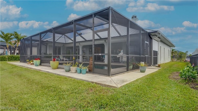 back of property featuring glass enclosure and a yard