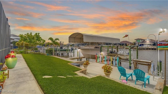 view of dock with a water view and a yard