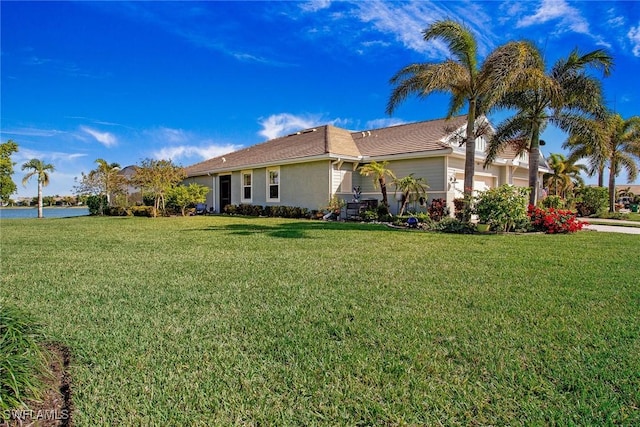 view of side of home featuring an attached garage, a lawn, and stucco siding