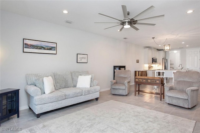 living room featuring light tile patterned floors, visible vents, baseboards, ceiling fan, and recessed lighting