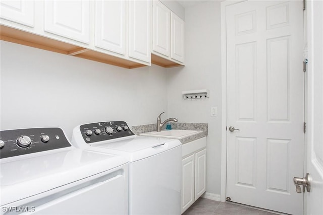 laundry room with washing machine and dryer, cabinet space, a sink, and light tile patterned flooring