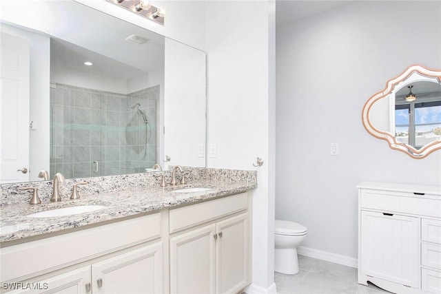 bathroom with a stall shower, a sink, toilet, and double vanity